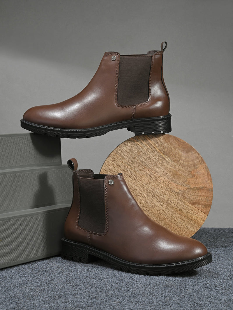 Black leather Classic Chelsea boot with elastic side panels, pull-tab at the heel, rounded toe, and a small metallic brand logo near the ankle.