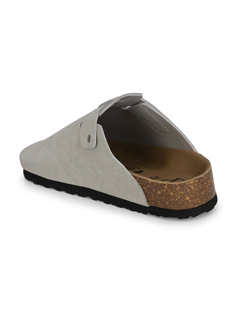 Nude suede slip-on clog with a black rubber sole and adjustable strap.