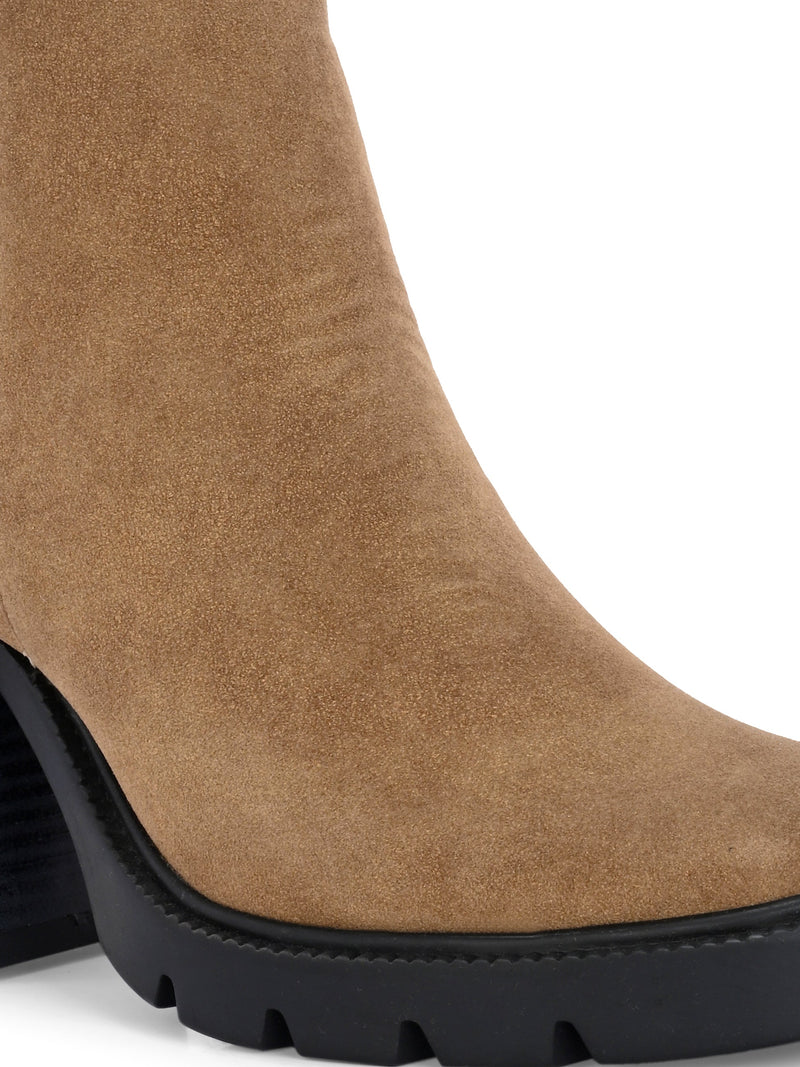Glossy black patent leather ankle boot with a chunky block heel, lug sole, and a gold logo detail near the collar.