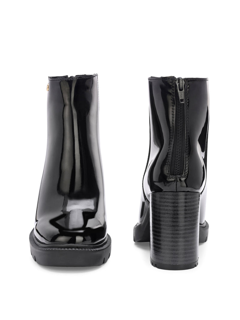 Glossy black patent leather ankle boot with a chunky block heel, lug sole, and a gold logo detail near the collar.