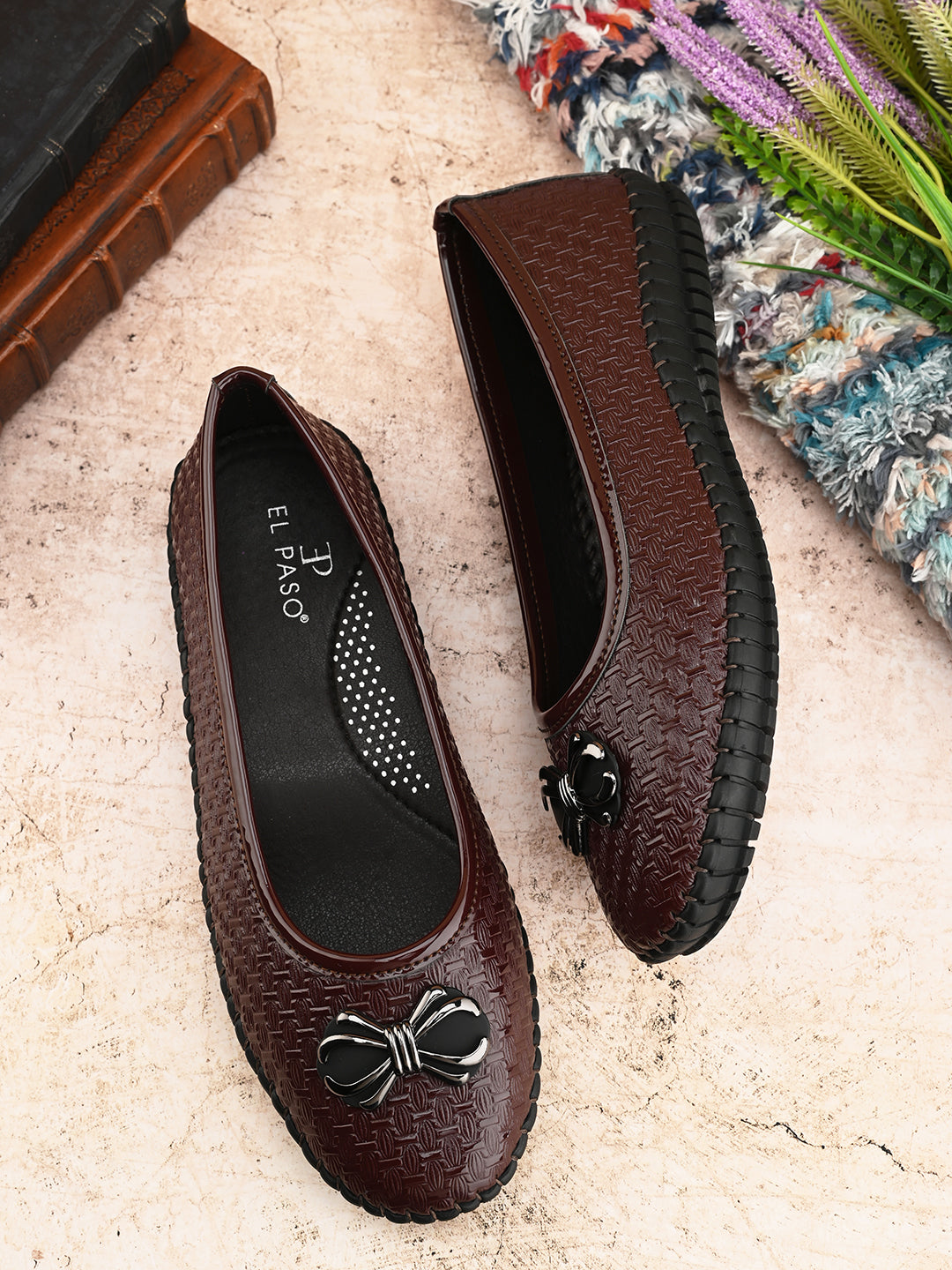 A brown Ballerina Flat with Bow for women, featuring a textured basket-weave upper, round toe, metallic bow detail, and a flexible black rubber outsole for comfort and casual wear.