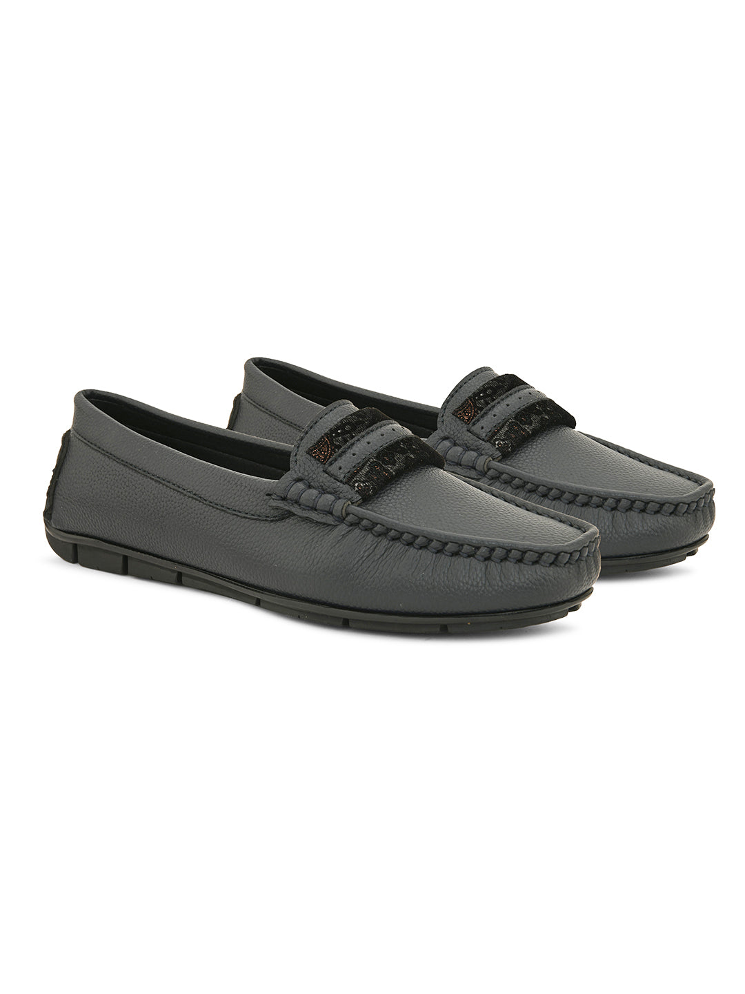 A single dark gray leather sleek loafer for women with a textured sole and decorative strap across the front.